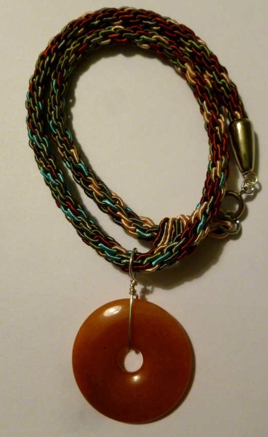 orange carnelian gemstone pendant on brown, blue, and